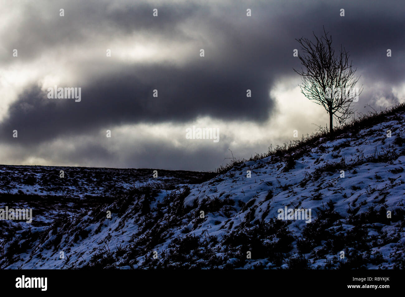 Neve e nuvole temporalesche in inverno a Ilkley Moor Foto Stock