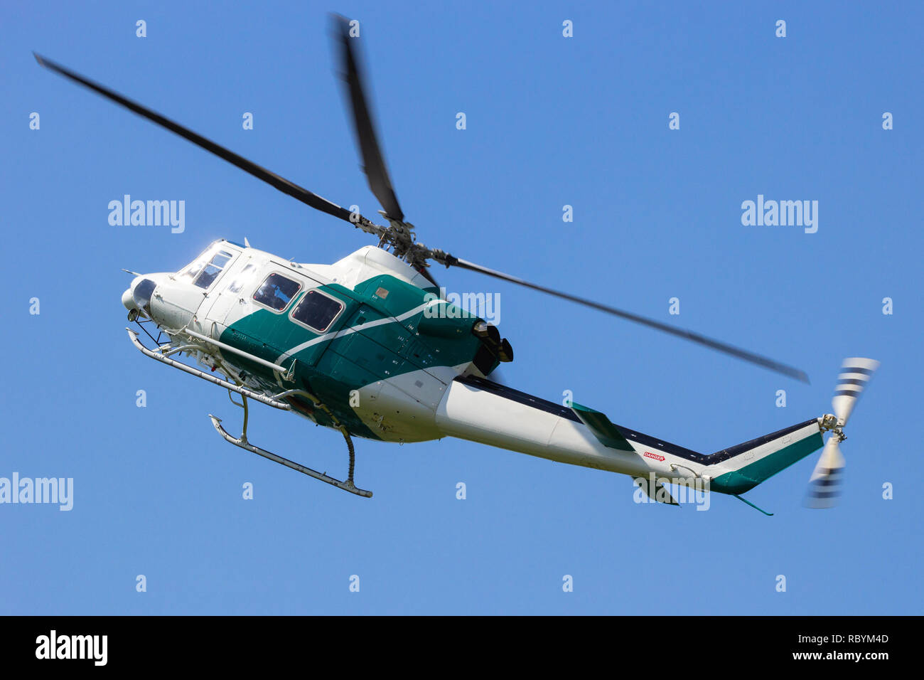 Elicottero bianco in volo con un cielo blu sullo sfondo. Foto Stock