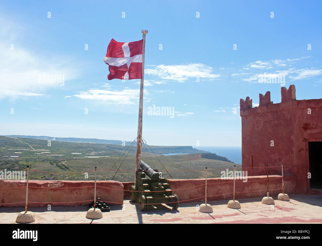 Sulla torre rossa, nel nord di Malta, con Canon e bandiera Maltese Foto Stock