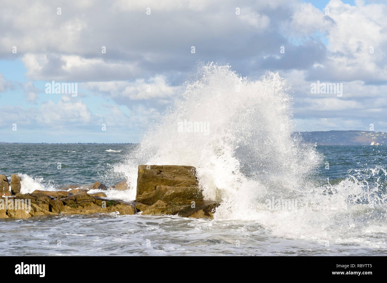 Esplosione di acqua come onde infrangersi contro le rocce,energia da onda viene rilasciato in un esplosione di acqua. Foto Stock