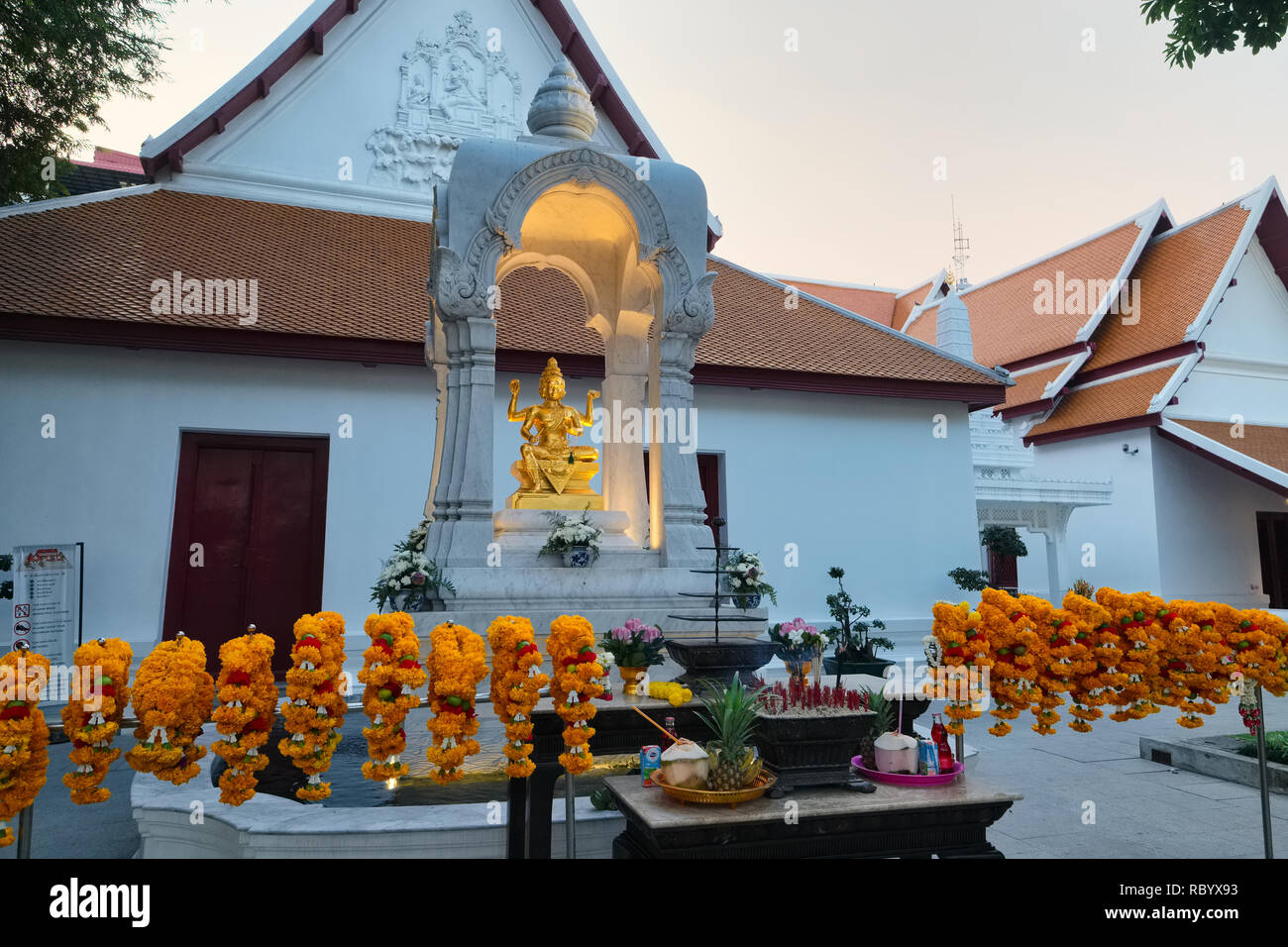 Il Tempio Brahmin (Bot Phram) o Devasathan / , gestito da sacerdoti thailandesi Brahmin; con una statua Brahma circondata da ghirlande calendule; Bangkok, Thailandia Foto Stock