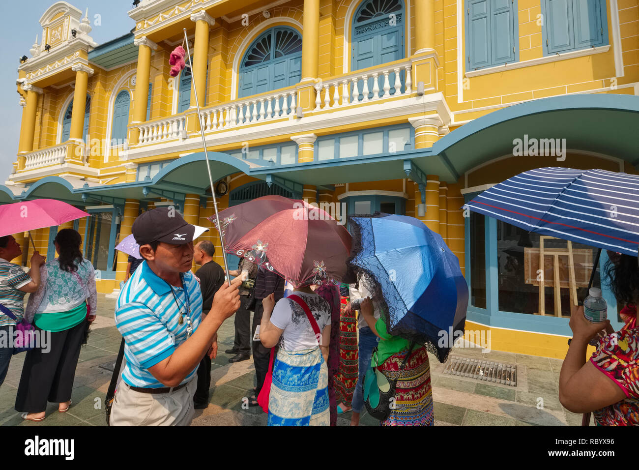 Un tour cinese guida davanti a un edificio di stile coloniale a Bangkok, Thailandia, pastori del suo tour cinese dal gruppo di Wat Phra Kaew a Tha Chang Pier Foto Stock