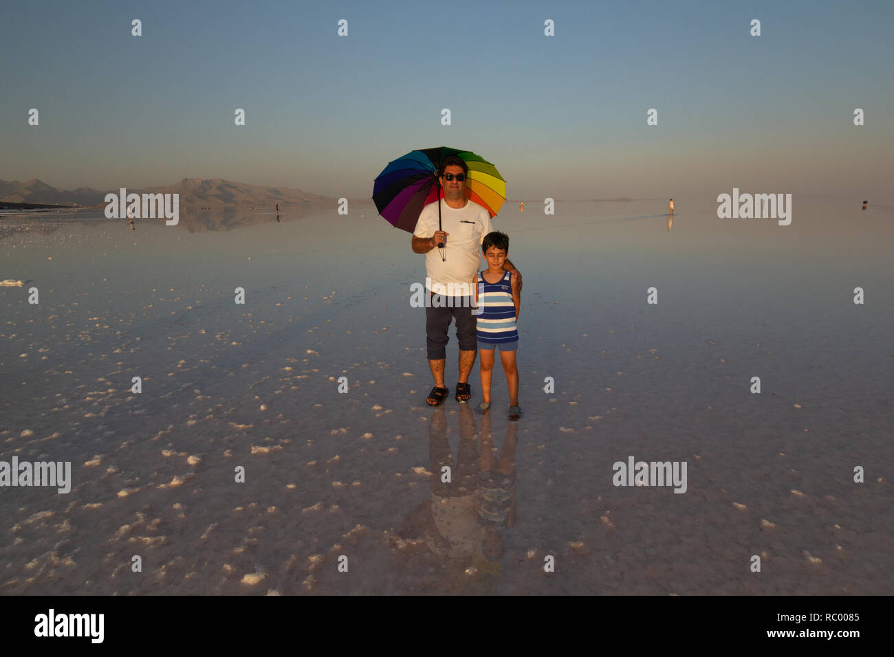 Un uomo con il suo figlio sulla distesa di sale del lago di Urmia, West Azerbaijan provincia, Iran Foto Stock