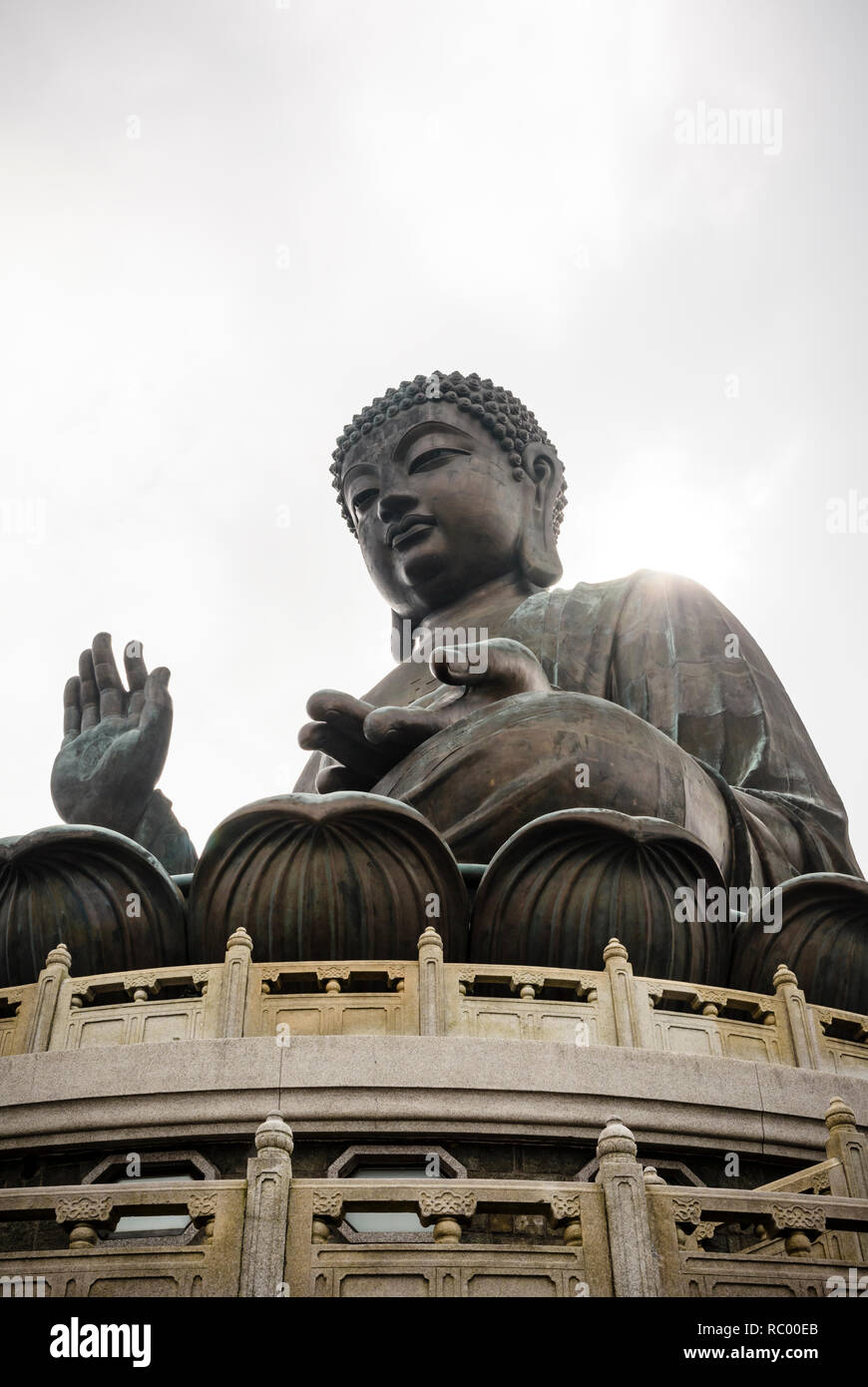 Raggi di sole rompere attraverso il cloud per riflettere su off la spalla del bronzo Tian Tan Buddha, Isola di Lantau, Hong Kong Foto Stock