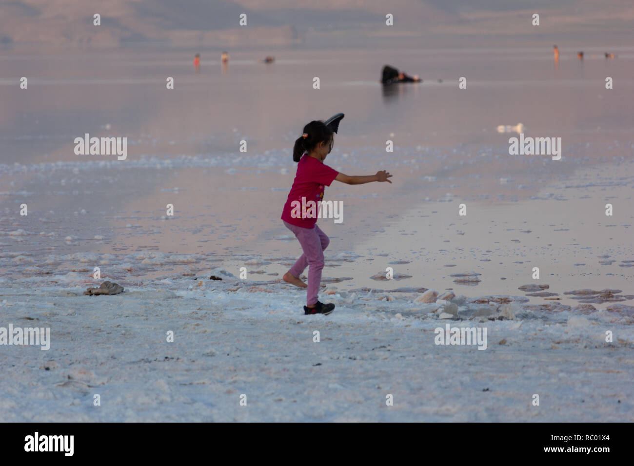 Una ragazzina è il salto nella distesa di sale del lago di Urmia, West Azerbaijan provincia, Iran Foto Stock