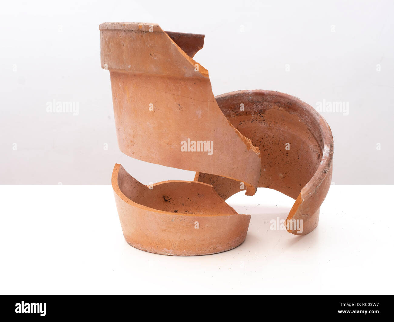 La rottura di un vaso di terracotta sulla superficie bianca, il gelo. Foto Stock