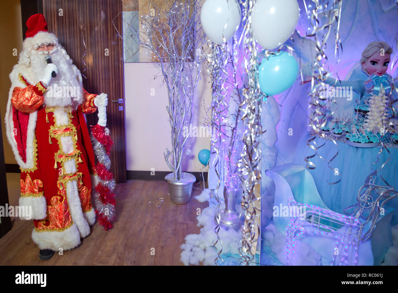 Padre Frost parla con un microfono . Babbo Natale sta cantando canzoni di Natale contro . Uomo in Santa Claus suit in posa con microfono. Foto Stock