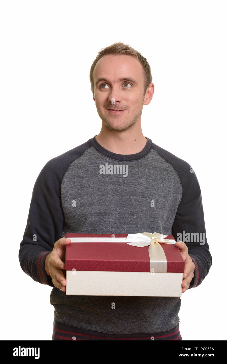 Felice uomo caucasico azienda confezione regalo mentre pensando pronto per Va Foto Stock