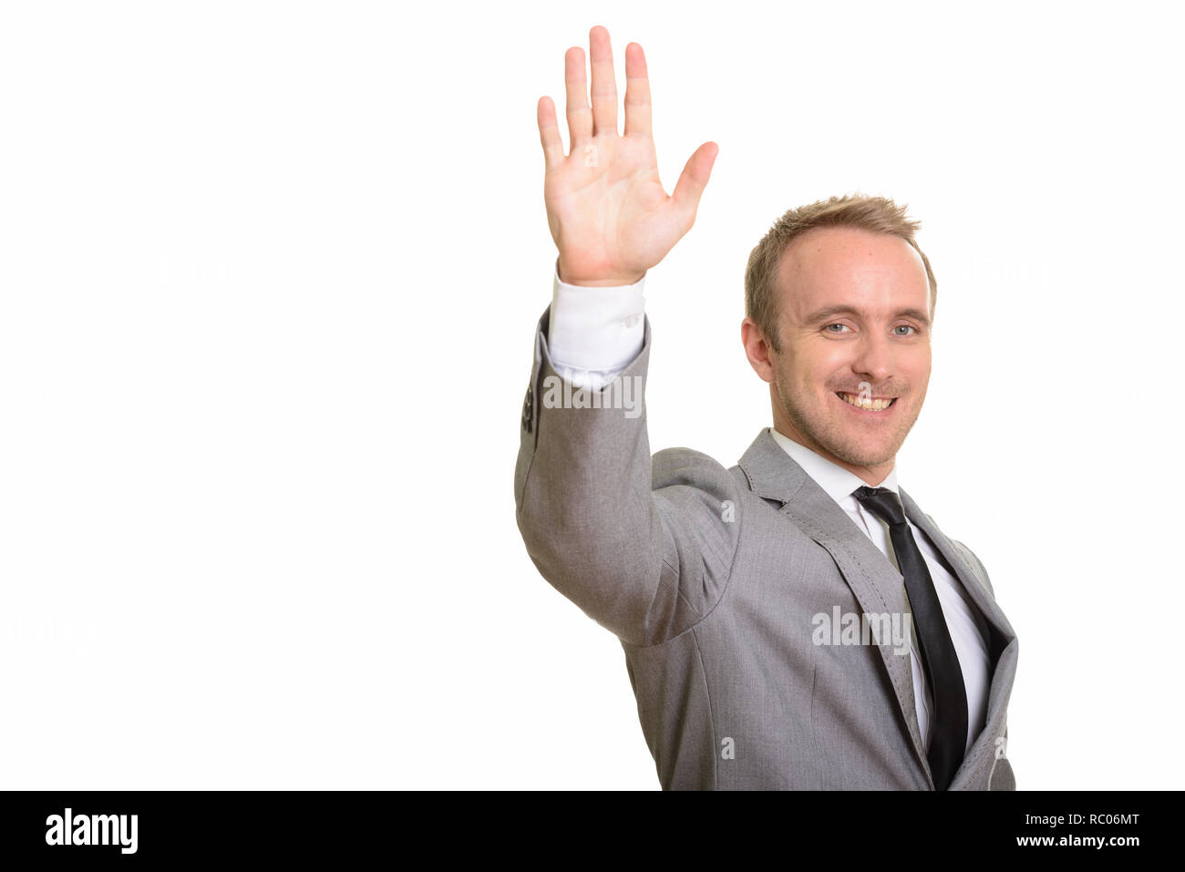 Felice bello imprenditore caucasico alzando la mano isolata contro uno sfondo bianco Foto Stock