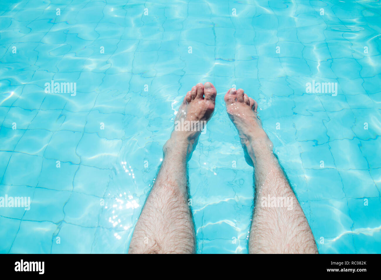 Una foto di una coppia di piedi in acqua turchese Foto Stock