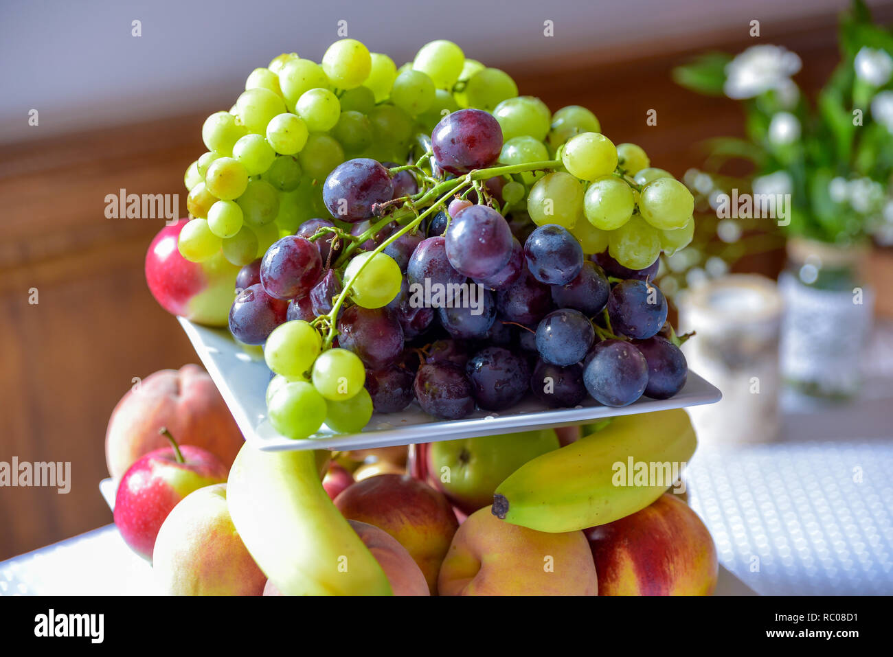 Un cesto di frutta è riempito con una varietà di prodotti colorati. Foto Stock