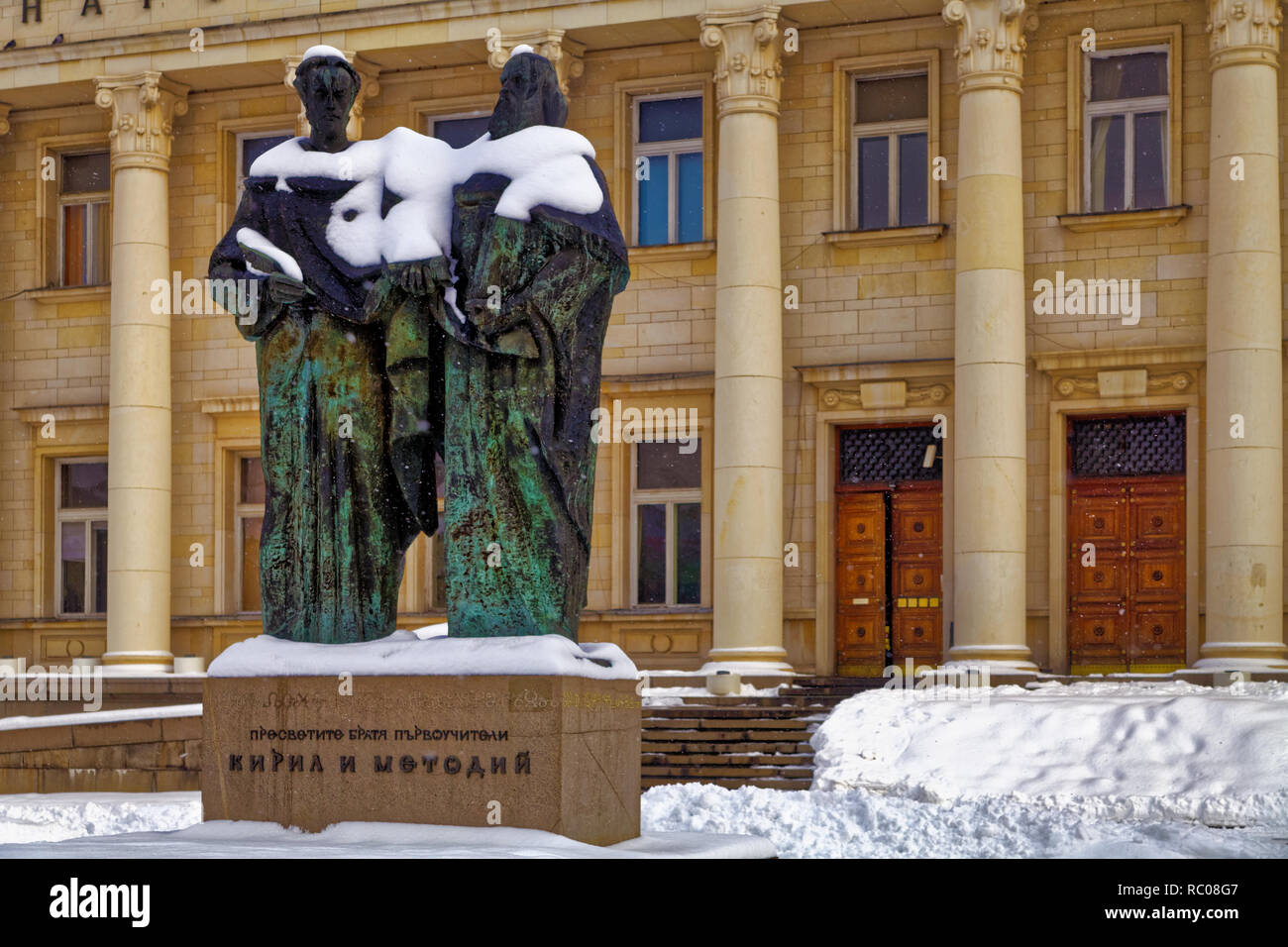 Statua dei santi fratelli Cirillo e Metodio, nella neve di fronte alla Biblioteca Nazionale. Lo script cirillico prende il nome da Cyril Foto Stock