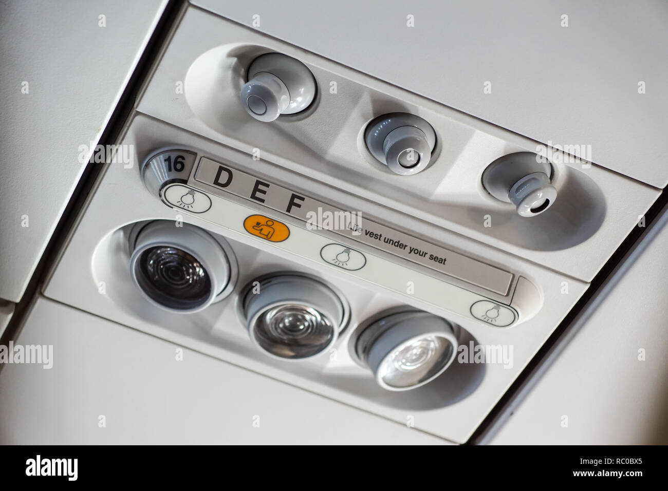Interno cabina dell'aeromobile, luci, di aria condizionata e pannello di segni al di sopra del sedile Foto Stock
