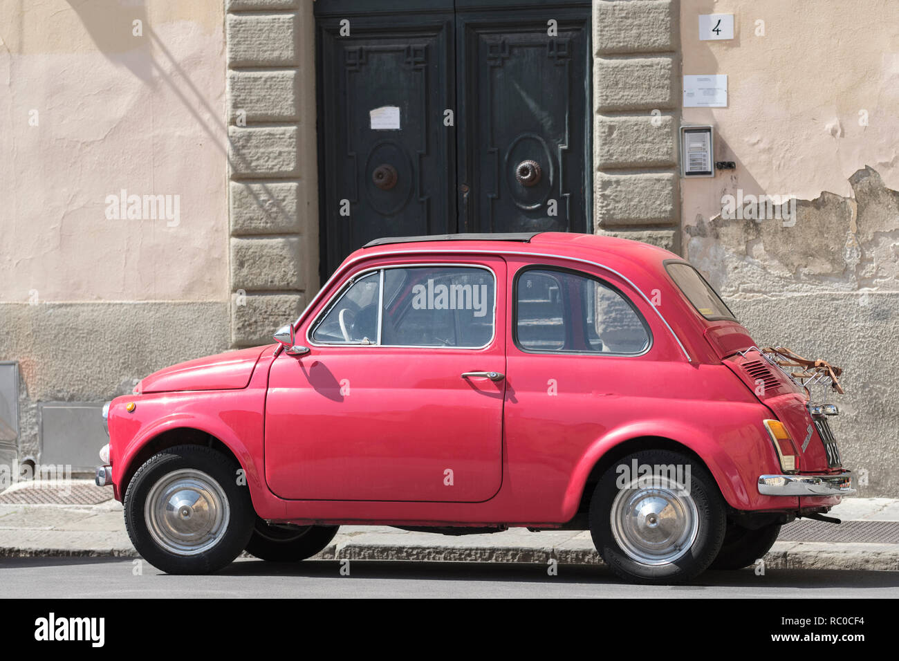 Vecchia auto rossa, Fiat, parcheggiato sulla strada fuori porta, Pisa. Toscana; Italia; Europa; Foto Stock