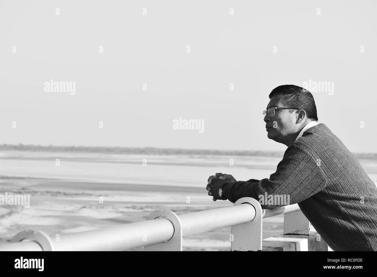 Un uomo in piedi su un ponte e guardando in giro Foto Stock