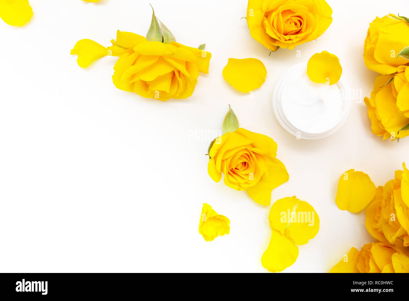 Botanico aromatico cosmetici. Dermocosmesi home trattamenti spa con petali gialli, bocciolo di rosa, naturale crema per il viso Foto Stock