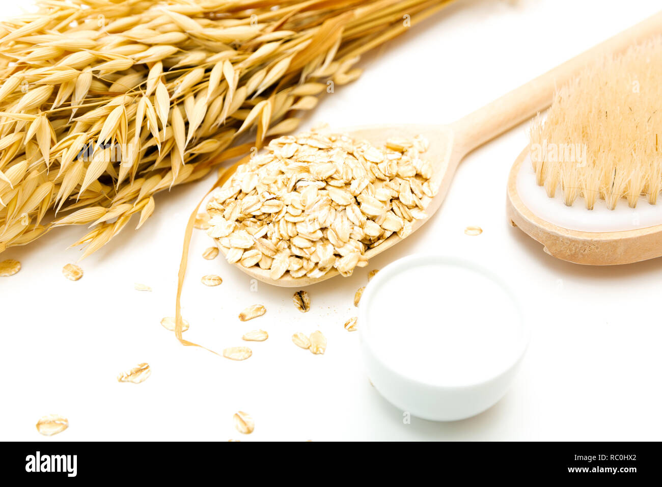 Pelle naturale prodotto di pulitura per body detox. Fiocchi di avena, panna, latte di avena, scrub del corpo spazzola, tavolo bianco, home spa. Foto Stock