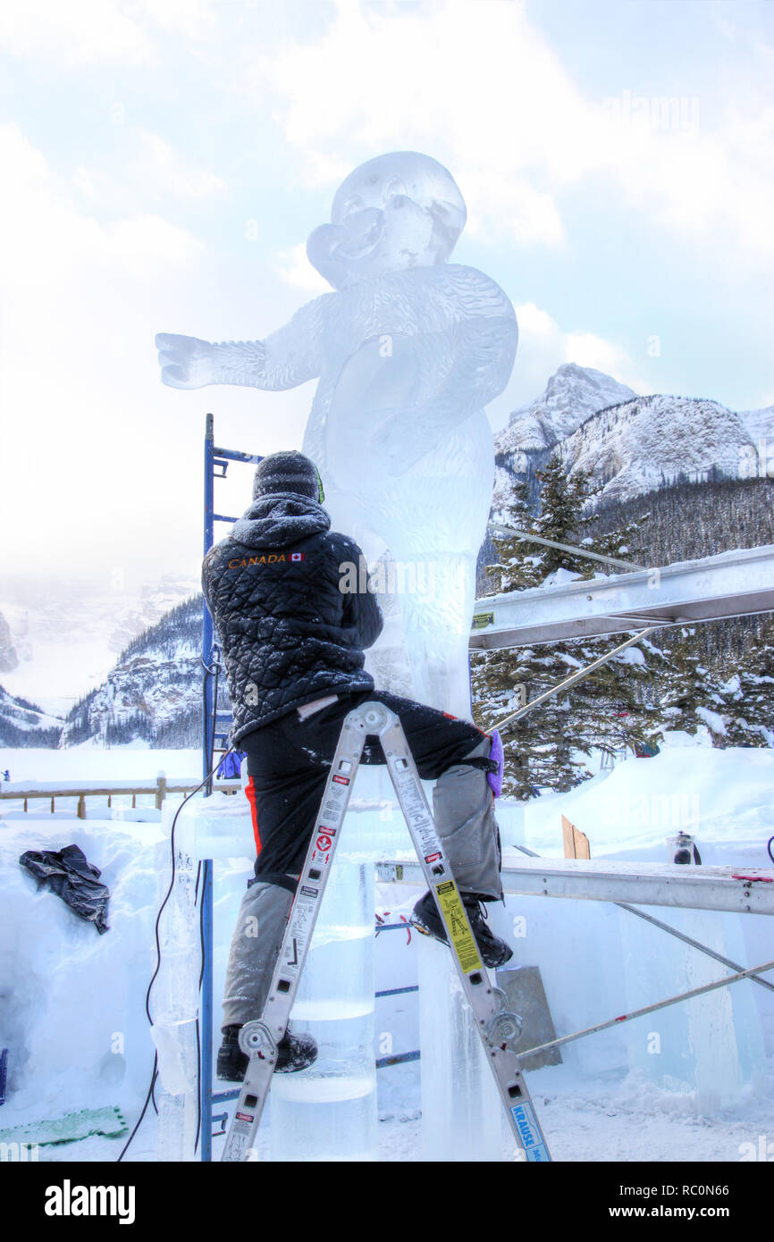 Il Lago Louise, CANADA - Jan 22, 2011: Un ghiaccio scultore scolpisce un alto blocco di ghiaccio con un intaglio strumento durante il ghiaccio annuale Magic Festival tenutosi a Ca Foto Stock