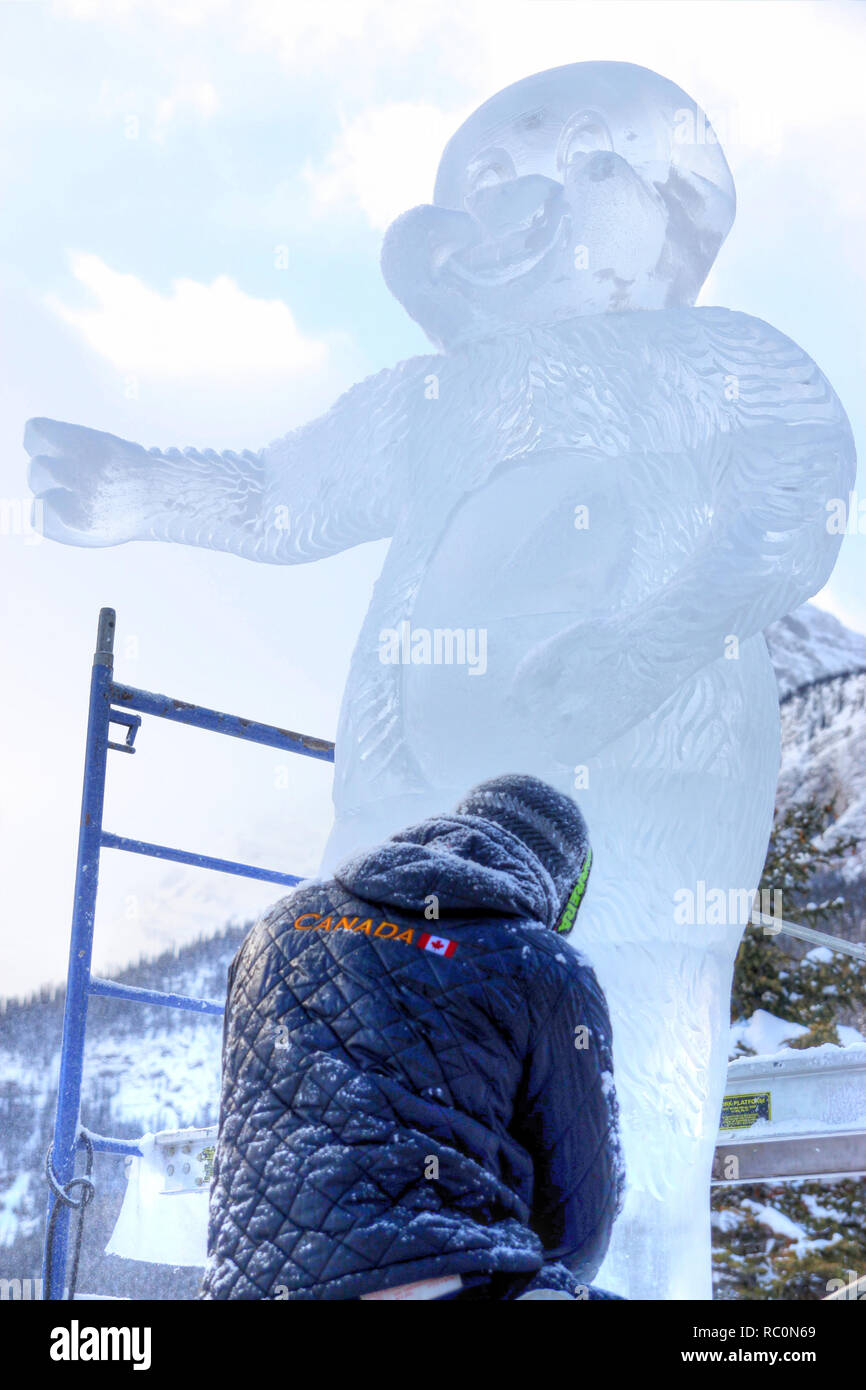 Il Lago Louise, CANADA - Jan 22, 2011: Un ghiaccio scultore scolpisce un alto blocco di ghiaccio con un intaglio strumento durante il ghiaccio annuale Magic Festival tenutosi a Ca Foto Stock