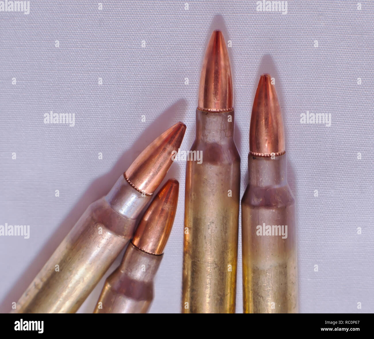 Quattro .223 fucile calibro proiettili su sfondo bianco Foto Stock