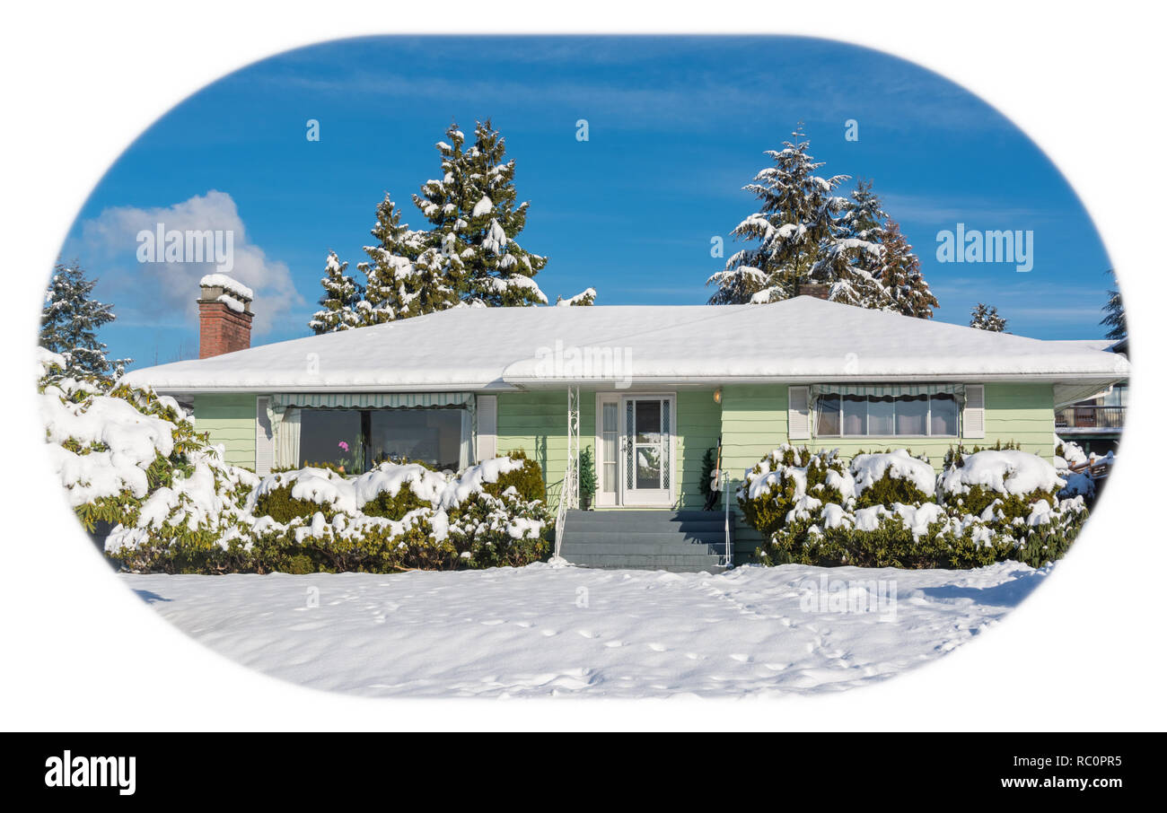 Famiglia casa residenziale con cortile anteriore nella neve. North American house su inverno giornata di sole Foto Stock