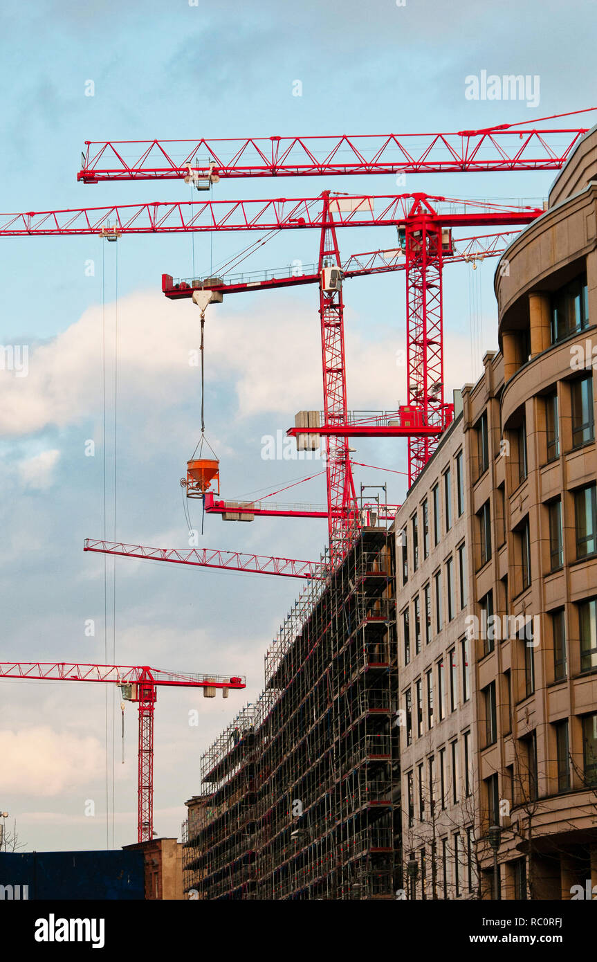 Torre Rossa gru sul sito in costruzione di un ufficio moderno edificio con i ponteggi, costruzione moderna e architettura, città moderna, business e Foto Stock