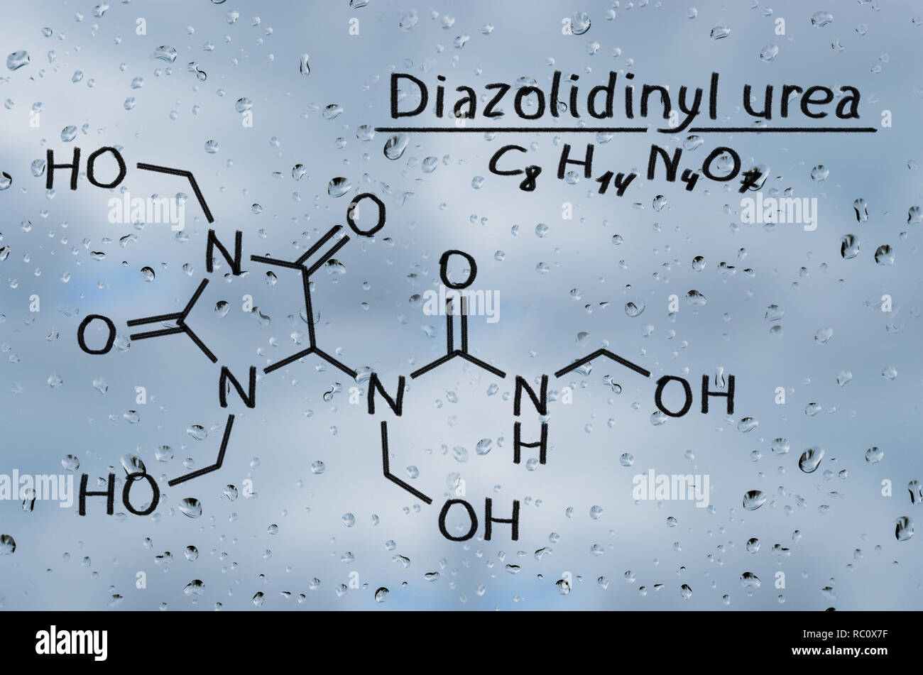 Modello strutturale di diazolidinil urea sul vetro con gocce di pioggia. Foto Stock
