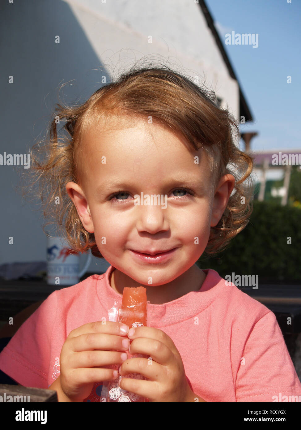 Felice bambina mangiare saporito per lecca-lecca di ghiaccio Foto Stock