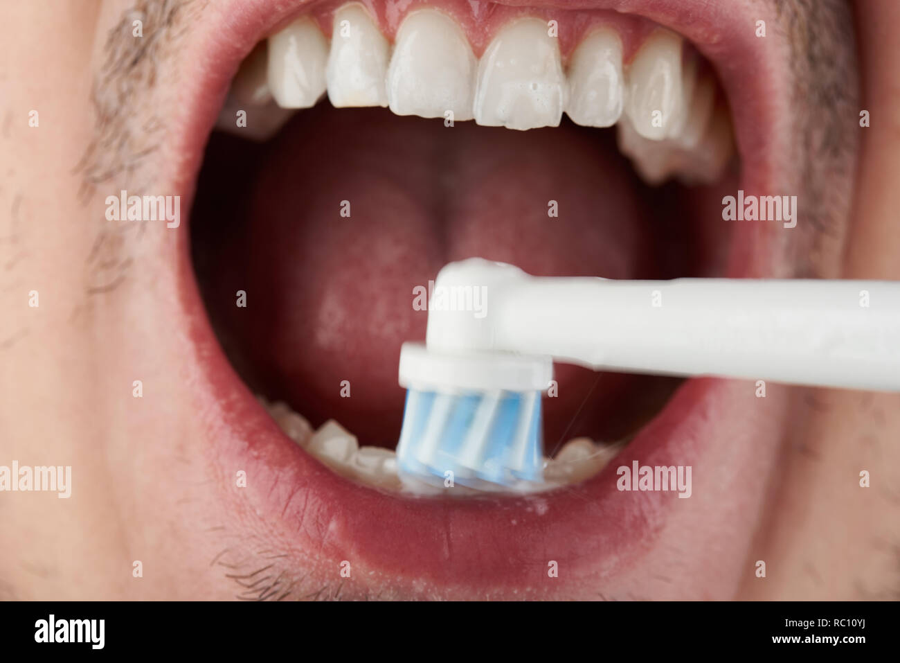 La pulizia dei denti con spazzolino elettrico vista ravvicinata Foto Stock