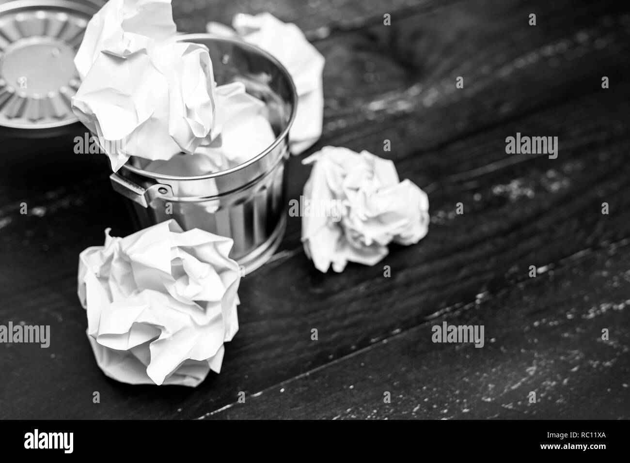Spazzatura sulla scrivania con impostazione scrunched palle di carta all'interno, il concetto di elaborazione e lottando per scrivere documenti Foto Stock