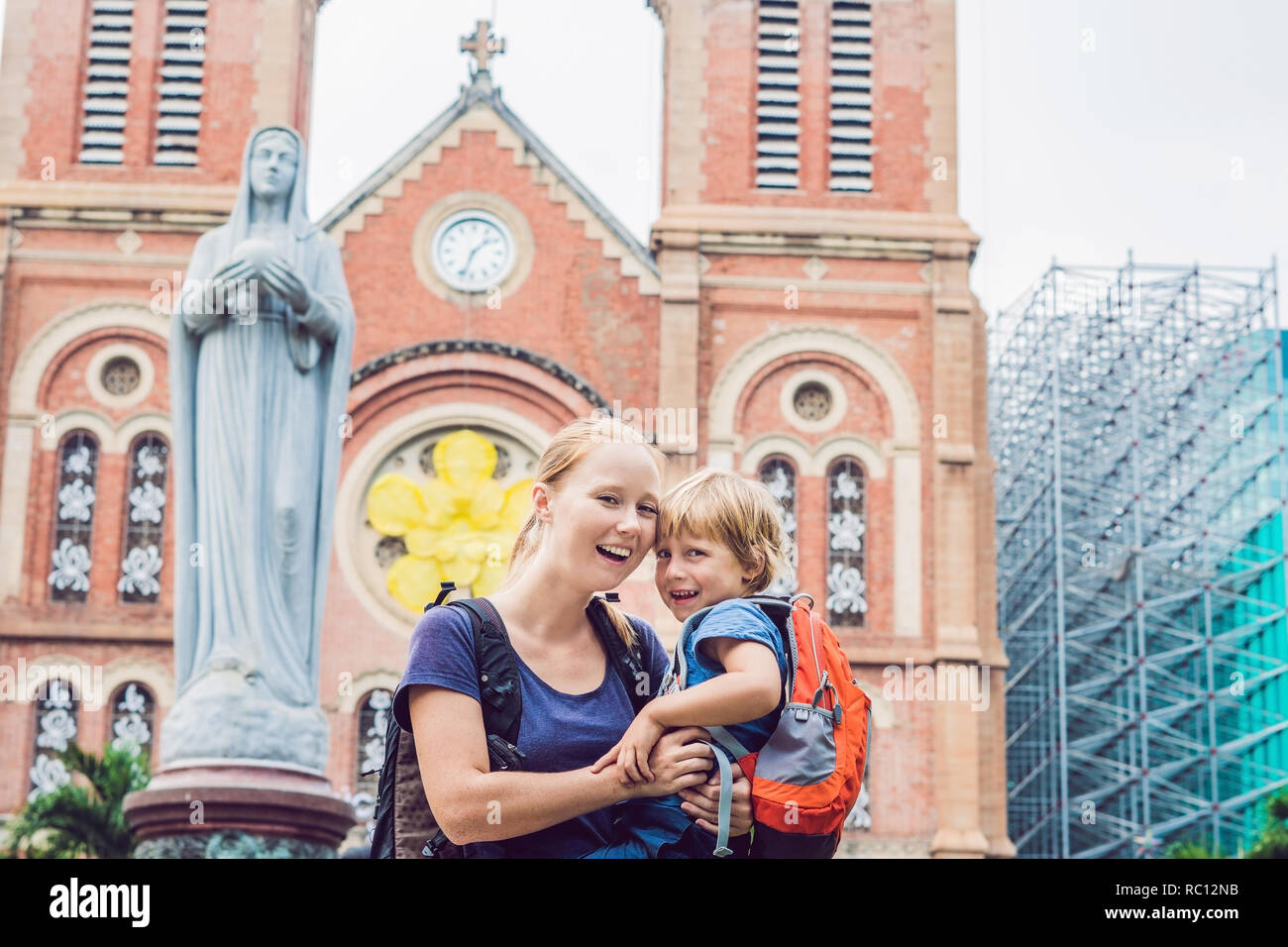 Madre e figlio in background Notre dame de Saigon cattedrale, costruire nel 1883 nella città di Ho Chi Minh, Vietnam. Foto Stock
