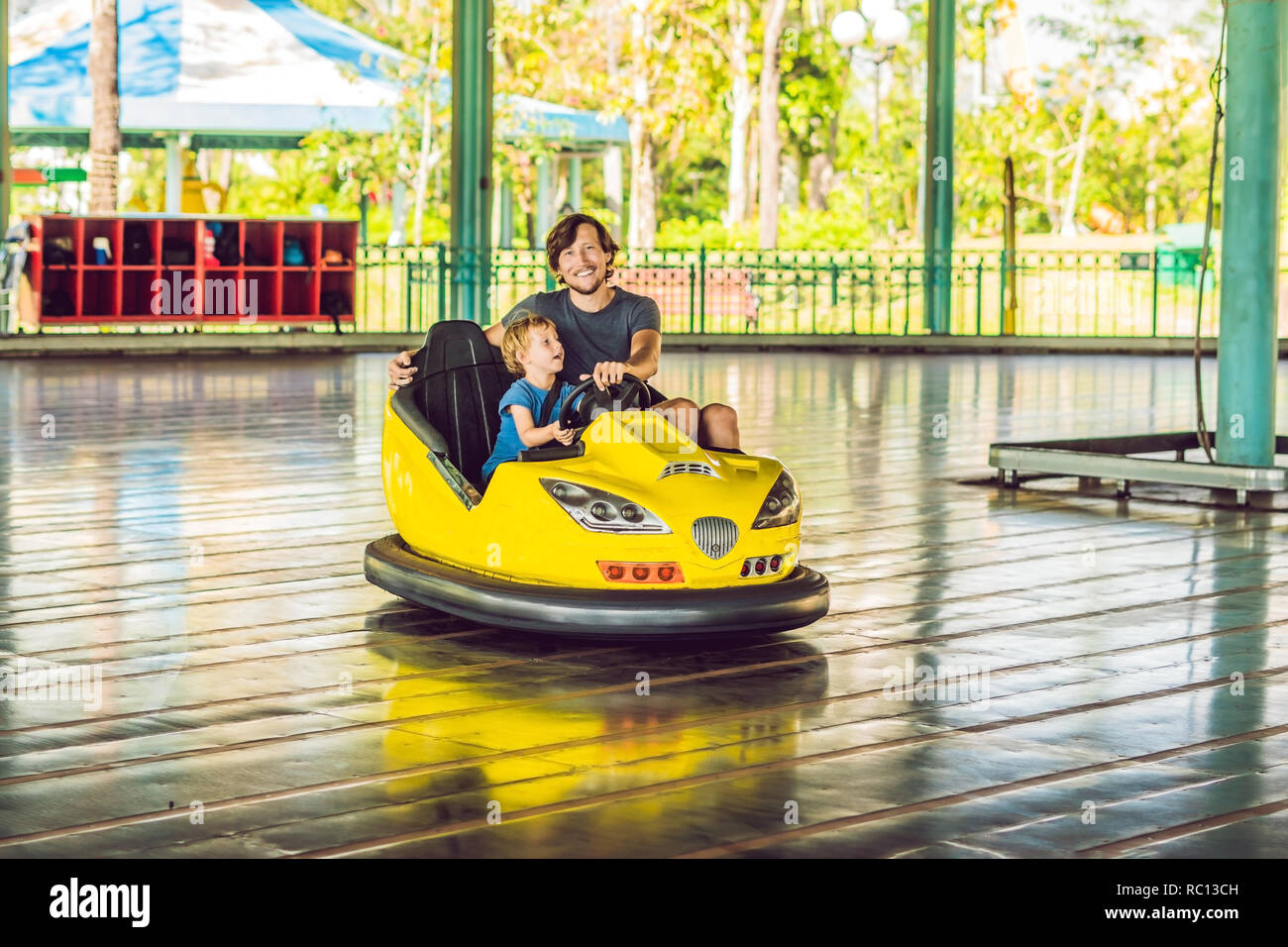 Padre e figlio avente una corsa nel paraurti auto presso il parco di divertimenti Foto Stock