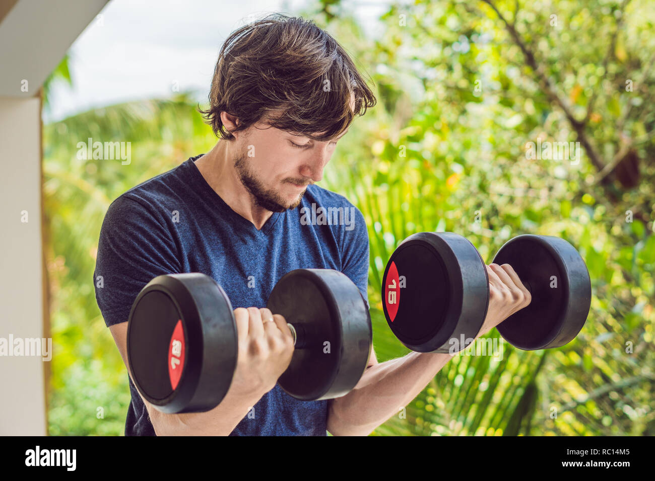 Bicipite curl - peso formazione uomo fitness al di fuori lavoro bracci sollevando i pesi facendo bicipite riccioli. Maschio modello sport esercizio all'aperto come parte di uno stile di vita sano Foto Stock