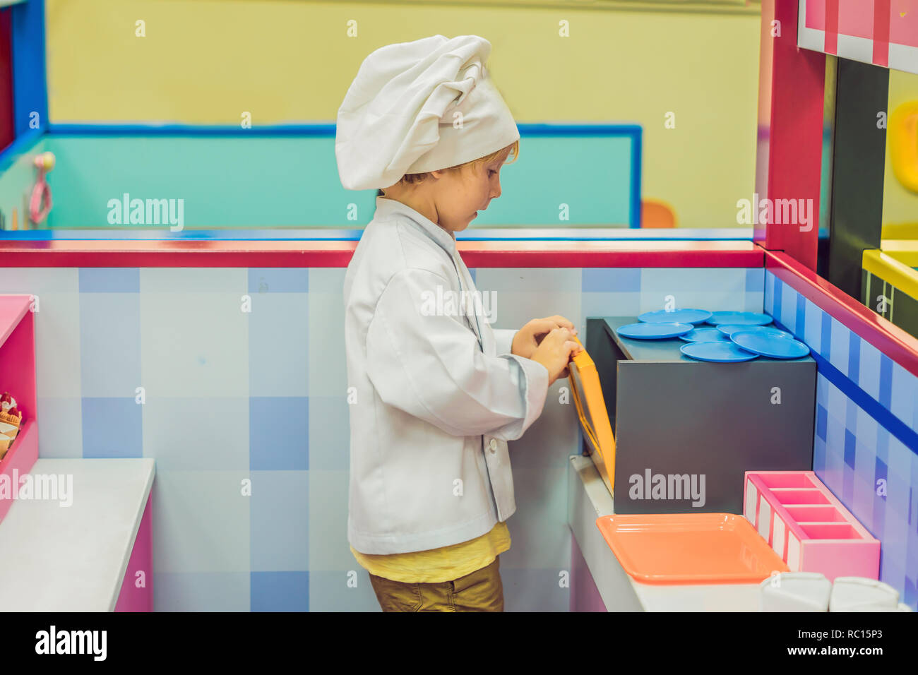 Il ragazzo gioca il gioco come se fosse un cuoco o un baker in bambini cucina Foto Stock