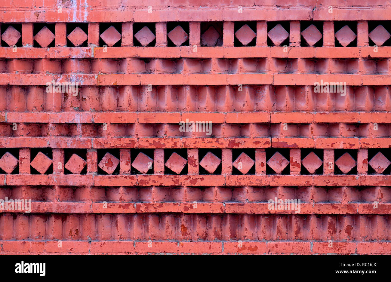 Foto macro di un rosso mattone ornamentali a parete con diversi disegni geometrici. Foto Stock
