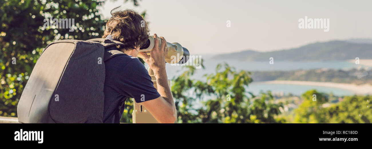 BUNNER uomo guarda nella gettoniera binocolo al mare Foto Stock