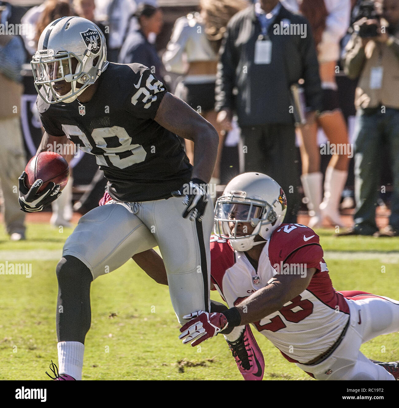 Oakland, la California, Stati Uniti d'America. Xix oct, 2014. Arizona Cardinals' Justin Bethel (28) affronta Oakland Raiders cornerback T.J. Carrie (38) dopo il kick off di Domenica, 19 ottobre 2014, a Oakland, in California. I Cardinali sconfitto i raider 24-13. Credito: Al di Golub/ZUMA filo/Alamy Live News Foto Stock