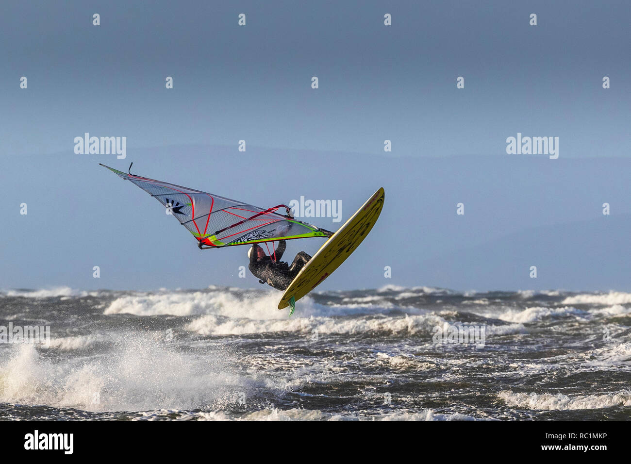 Firth of Clyde, Troon, Scozia. Il 13 gennaio 2019. Nella forte gales soffiando attraverso il Firth of Clyde, con velocità del vento in eccesso di 50mph, membri della locale windsurfing club da Troon, Ayrshire amano mostrare le loro abilità ed equilibrio. A volte le loro manovre acrobatiche sono impressionanti e talvolta abbastanza non come fine di essi vorrebbe! Credito: Findlay/Alamy Live News Foto Stock