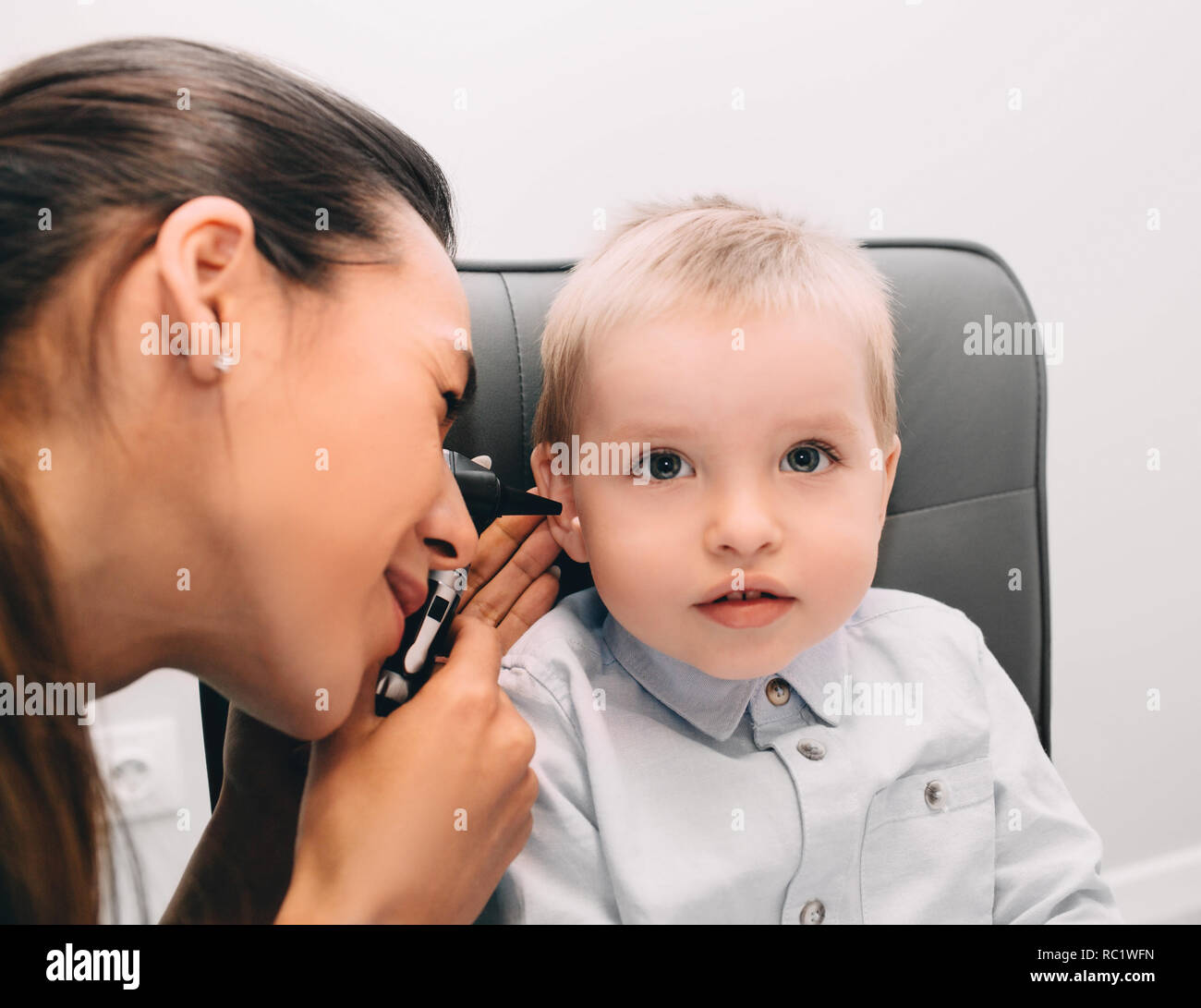 Audiologist medico facendo un orecchio esame con otoscopio a little boy Foto Stock