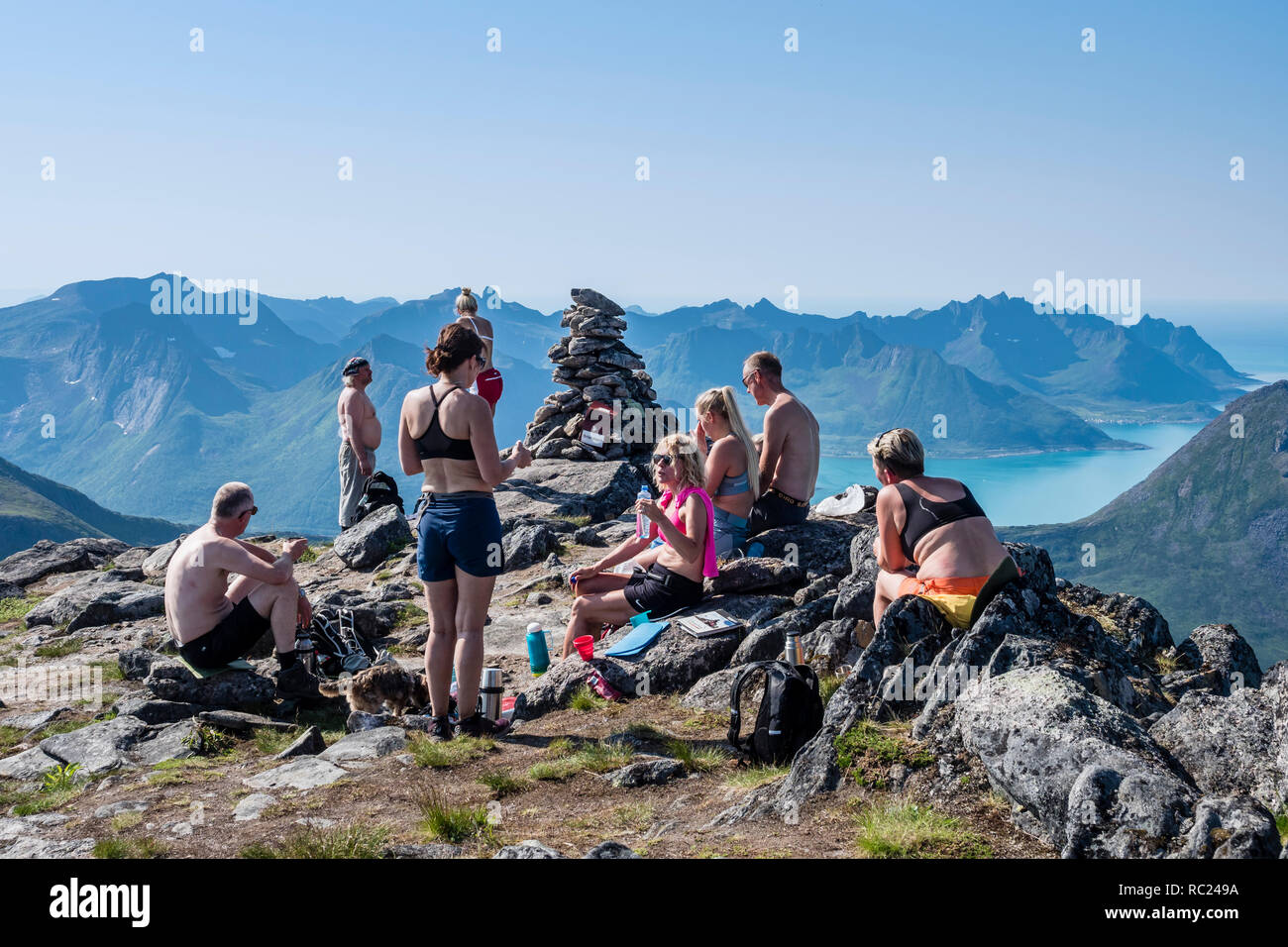 Gli escursionisti si prendono una pausa, caldo giorno d'estate, vista su Örnfjord, vertice Grytetippen montagna, isola Senja, Troms, Norvegia Foto Stock