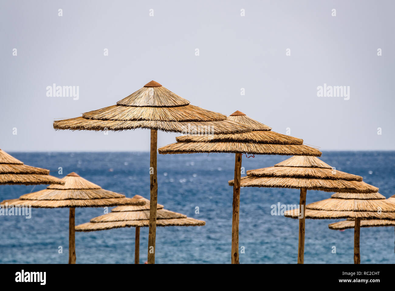 In vimini naturale paglia ombrelloni su un tropicale esotica spiaggia con  mare azzurro e cielo chiaro. San Giorgio spiaggia vicino a Gioiosa Marea,  Messina, Sicilia Foto stock - Alamy
