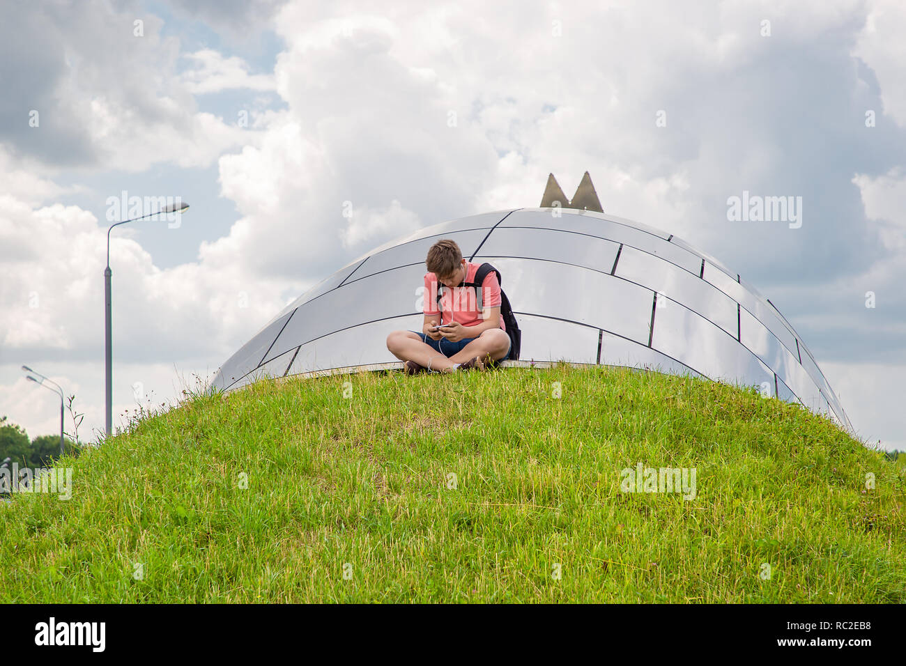 Mosca, Russia - Luglio 13, 2018: Lonely teenager, circondato da una grande città, ascoltare una musica di Mosca, Russia. Foto Stock