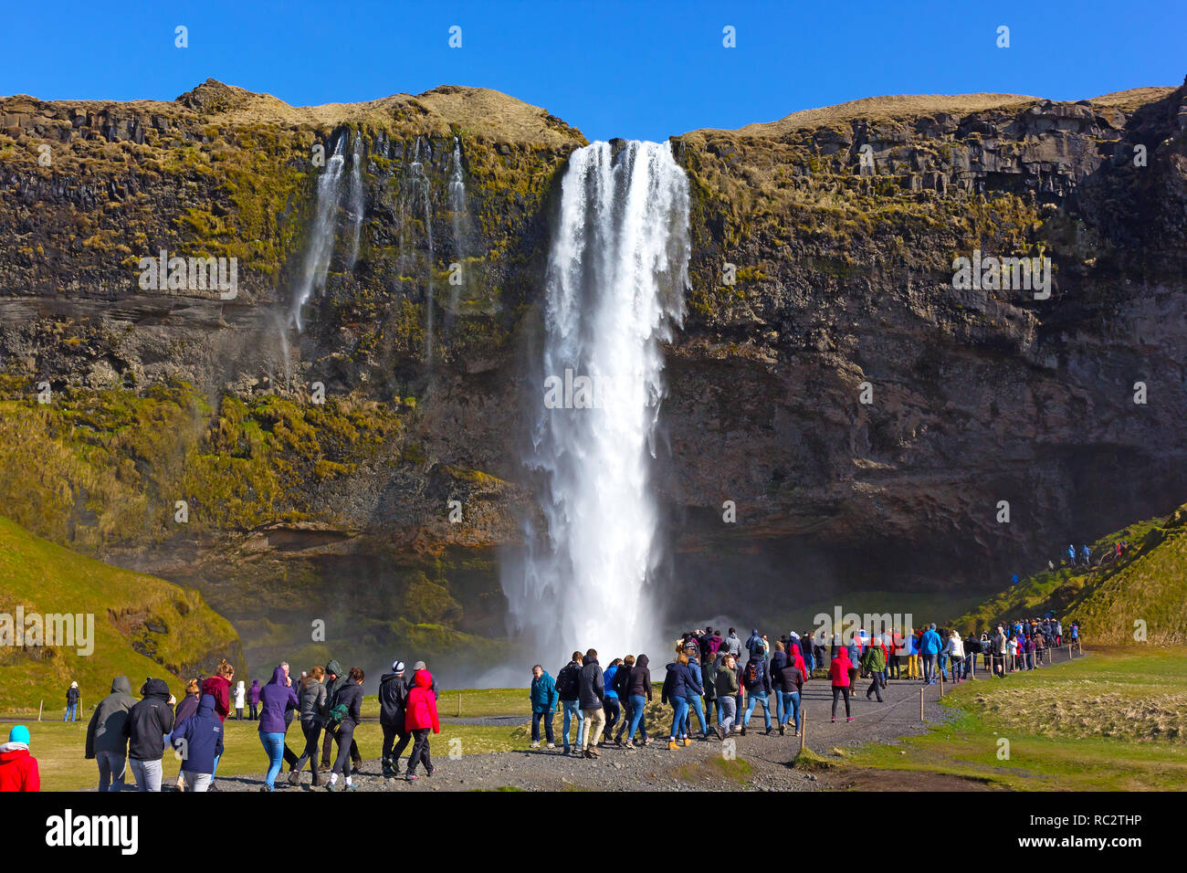 Affollate destinazioni turistiche - a cascata Skogafoss nel sud dell'Islanda. Over-turismo è una nuova tendenza emergente. Foto Stock