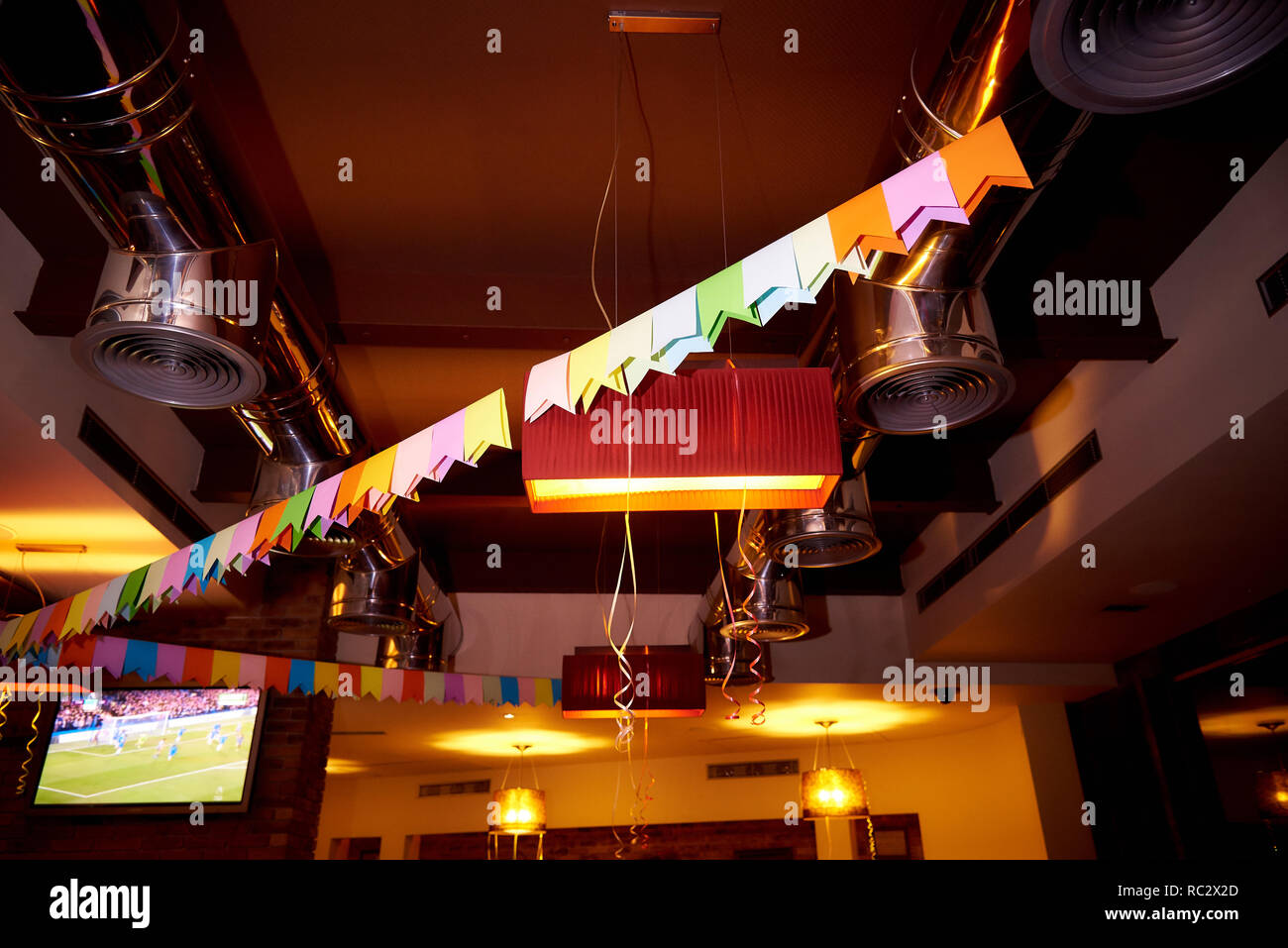 Il soffitto del pub è decorata con bandiere colorate e nastri. Foto Stock