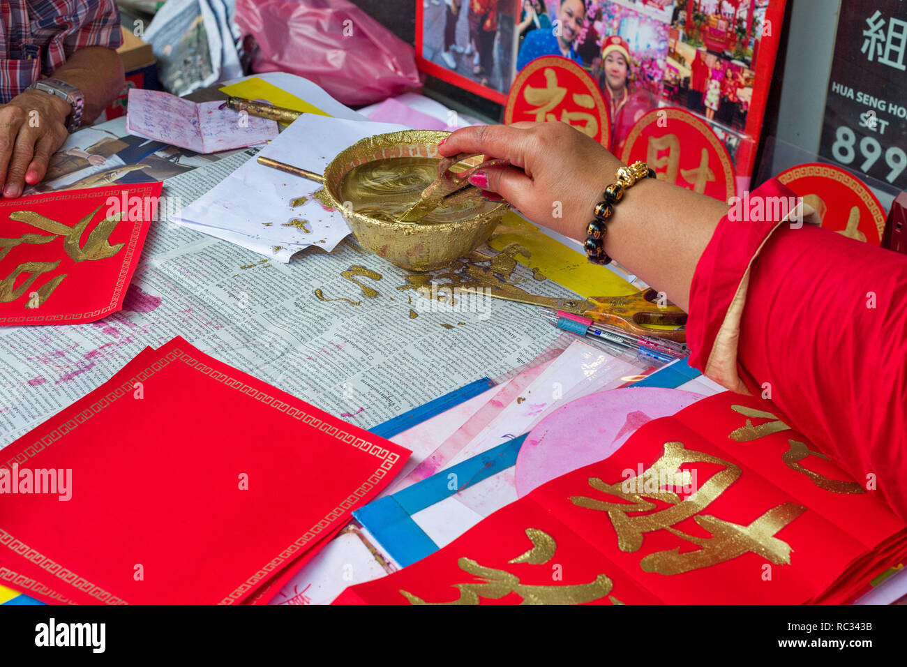 Un pittore dipinge calligraphed poesie per il nuovo anno cinese a Chinatown a Bangkok, in Thailandia Foto Stock
