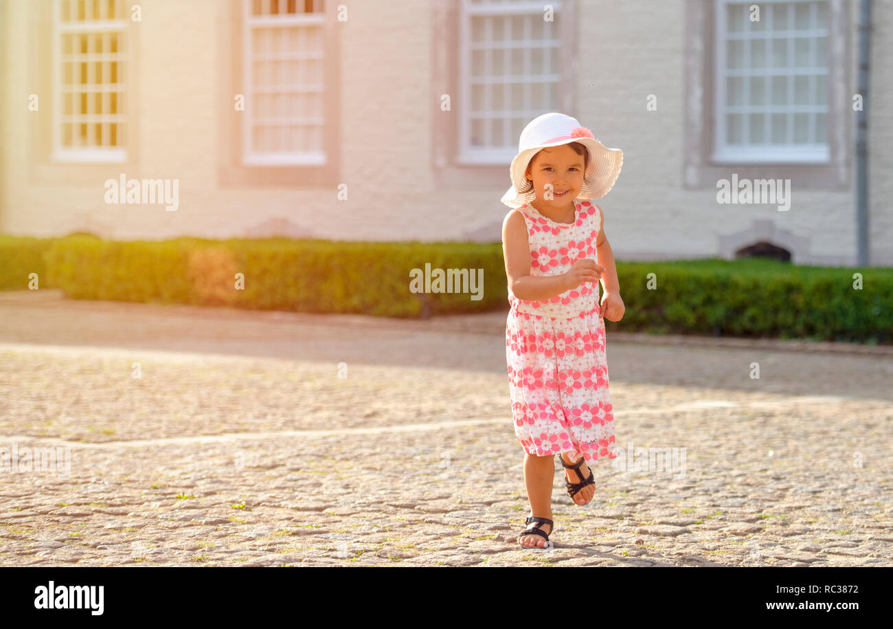 Bambina in esecuzione su strada in città Foto Stock