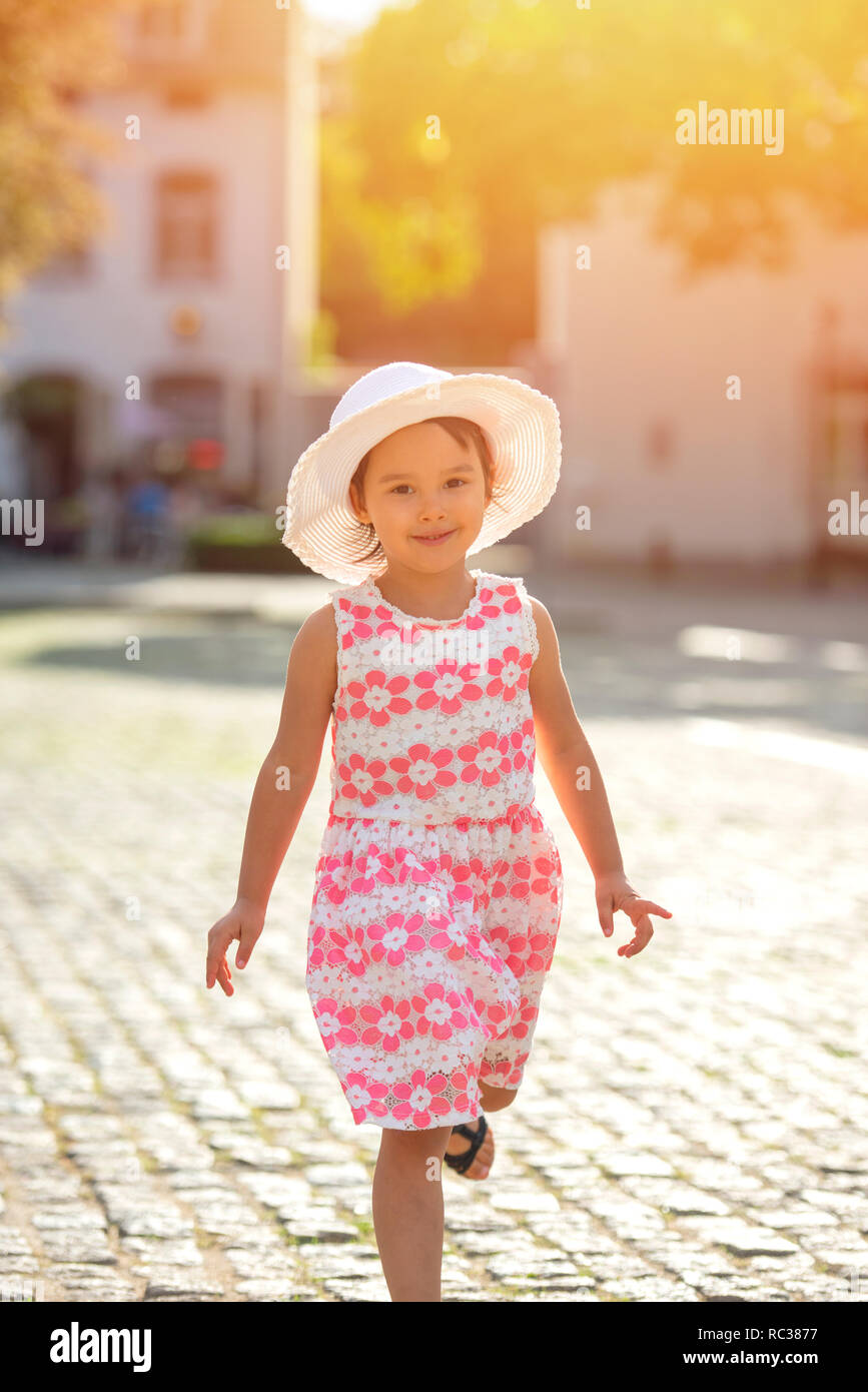 Bambina in esecuzione su strada in città .a piedi in strada. Foto Stock