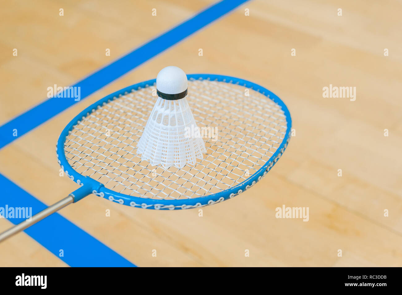 White badminton volano su una sala con pavimento a badminton .close up volani su badminton racchetta a badminton. Foto Stock