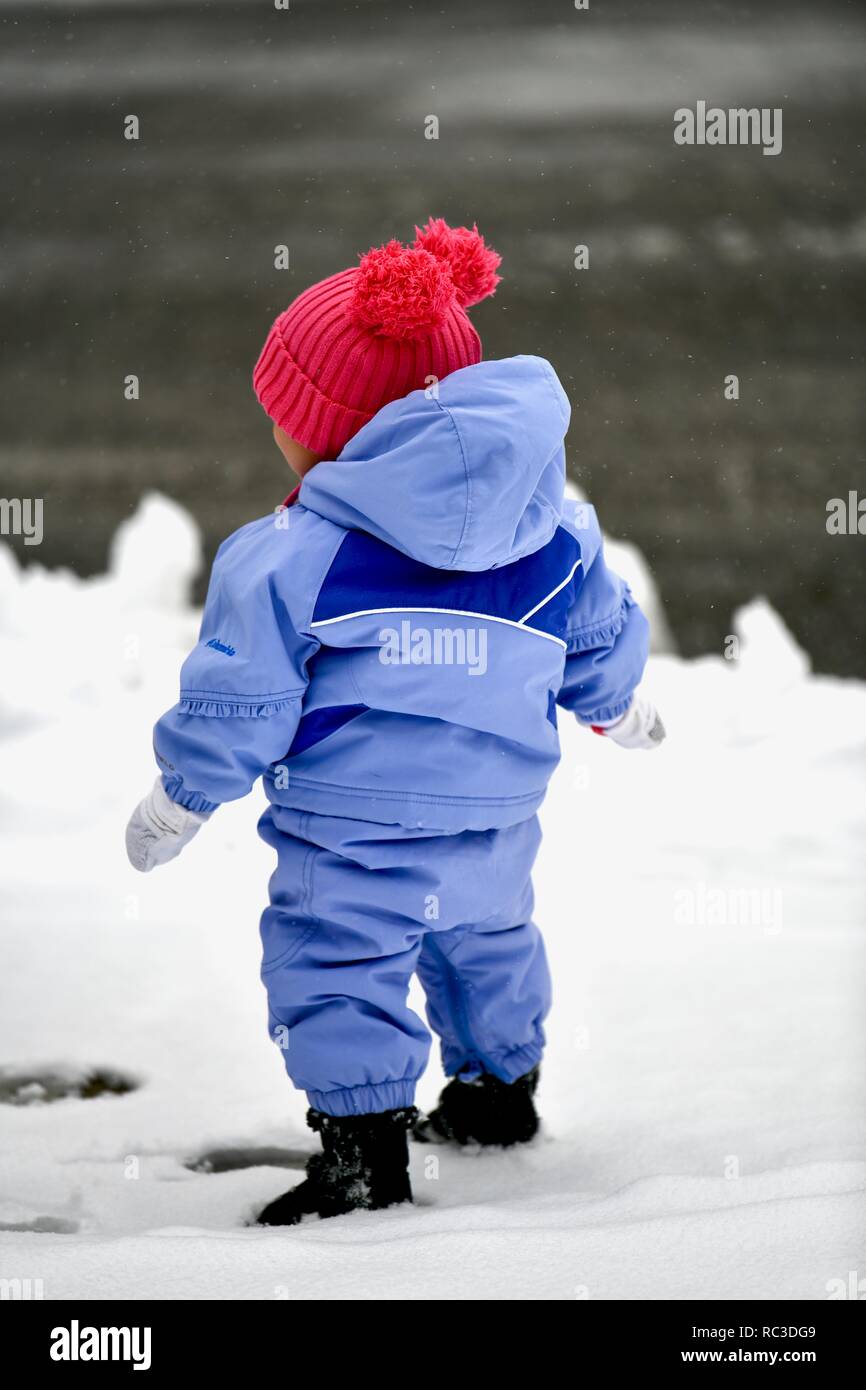 Un giovane bambino giocando fuori nella neve Foto Stock