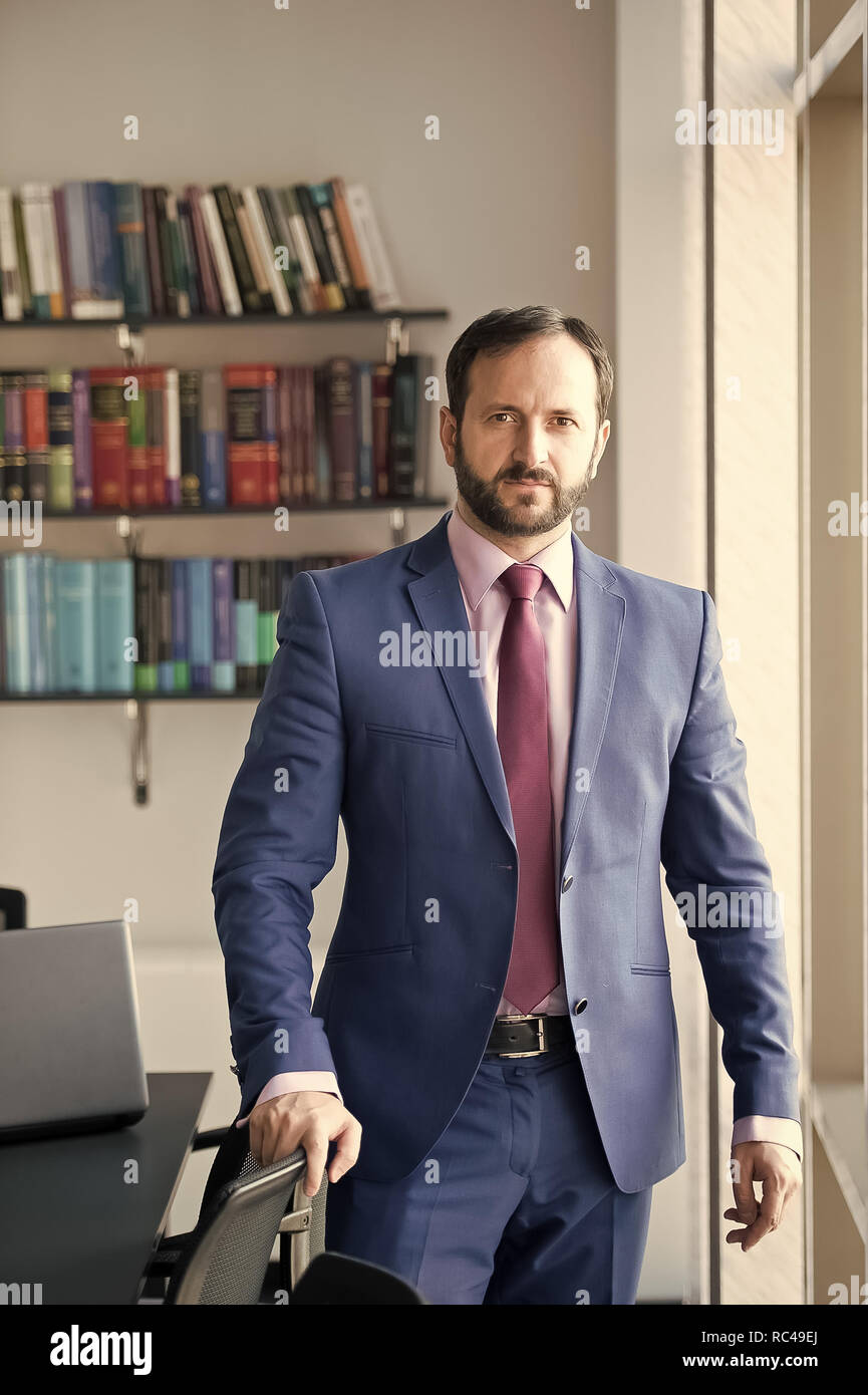 Uomo con la barba in blu abito formale. Imprenditore o direttore posa al  posto di lavoro. Business, concetto di imprenditorialità. Moda e stile,  codice di abbigliamento. Carriera, professione, lavoro Foto stock -
